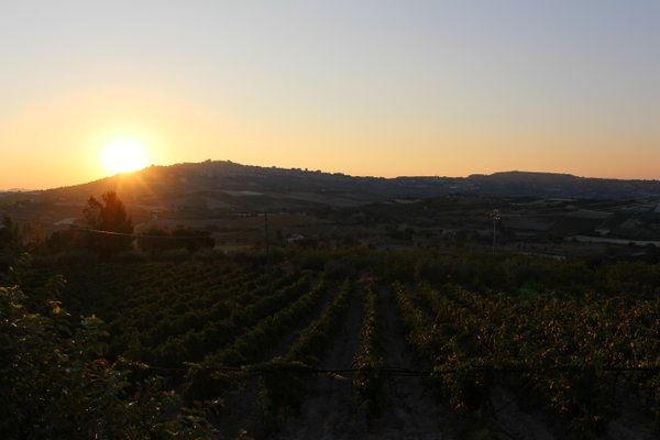 Der Blick zur Stadt Naro bei Sonnenaufgang. Der Ursprung unseres Olivenöls und der Weine für Ihren Genuss.